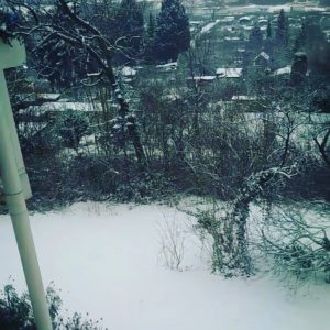 Fensterblick mit Schnee hinter dem Haus