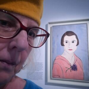 Selfie von Claudia mit gelber Mütze vor dem Selbstporträt von Suzanne Duchamp