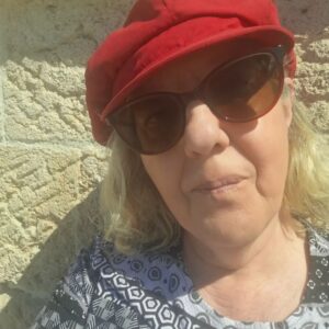 Claudia mit roter Mütze und dunkler Brille.