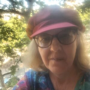 Claudia im Gegenlicht mit roter Schirmmütze. 