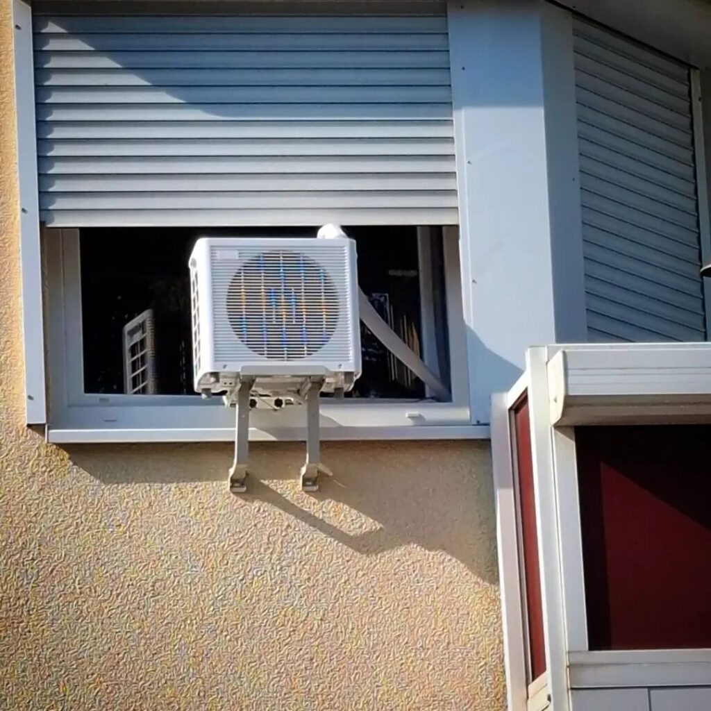Klimaanlage vor einem Fenster in einem Wohnblock
